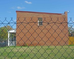 The now empty lot was once occupied by six attached row houses facing the left field wall, each with a small, enclosed backyard